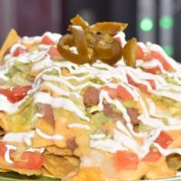 Regular Nachos · No meat. Yellow corn chips topped with refried beans, nacho cheese, lettuce, tomatoes, jalap...