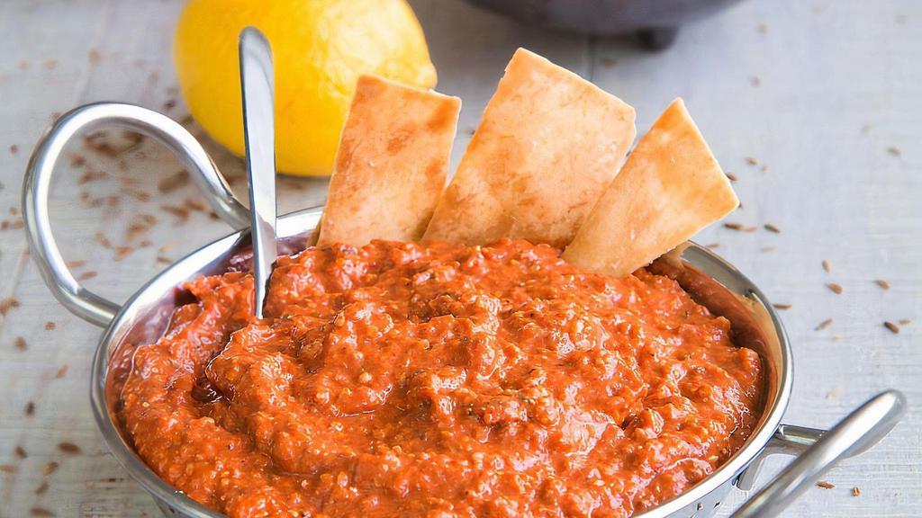 Muhammara Dip · a dip with origins from Syria, and more precisely from the city of Aleppo. The main ingredients in the recipe are bell pepper and walnuts, enriched with spices and pomegranate molasses. This spicy and sweet dip is delicious on its own or as a side dish. 8 oz.
