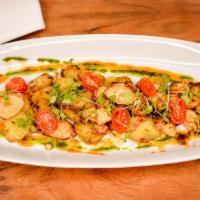 Pulpo Saltado · Sauteed octopus with fingerling potatoes over A bed of roasted garlic hummus and Spanish smo...