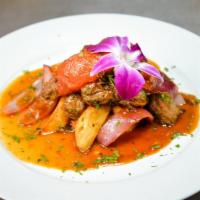 Lomo Saltado · Peruvian Stir-Fry. Filet mignon tips with sautéed onions, tomatoes, cilantro, and soy sauce ...