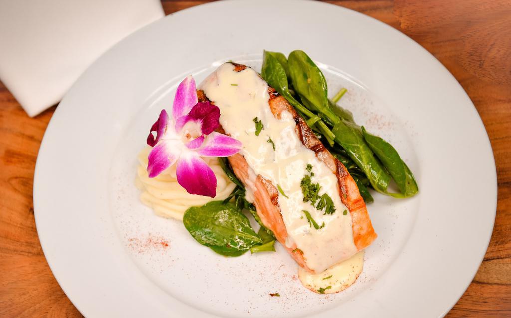 Salmon A La Parrilla · Grilled salmon, sautéed spinach, mashed potatoes served with A lemon thyme sauce.