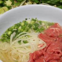 P06 - Eye Round Steak Pho · Eye round steak. Flat rice noodles in beef & chicken based broth with toppings; garnished wi...