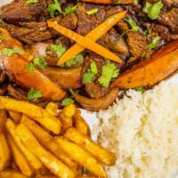 Lomo Saltado · Tender steak with sautéed onions & tomatoes, served with fries and rice.