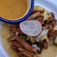 Al Pastor Taco · Marinated rotisserie pork. Served on a homemade corn tortilla with cilantro and onion. Homem...