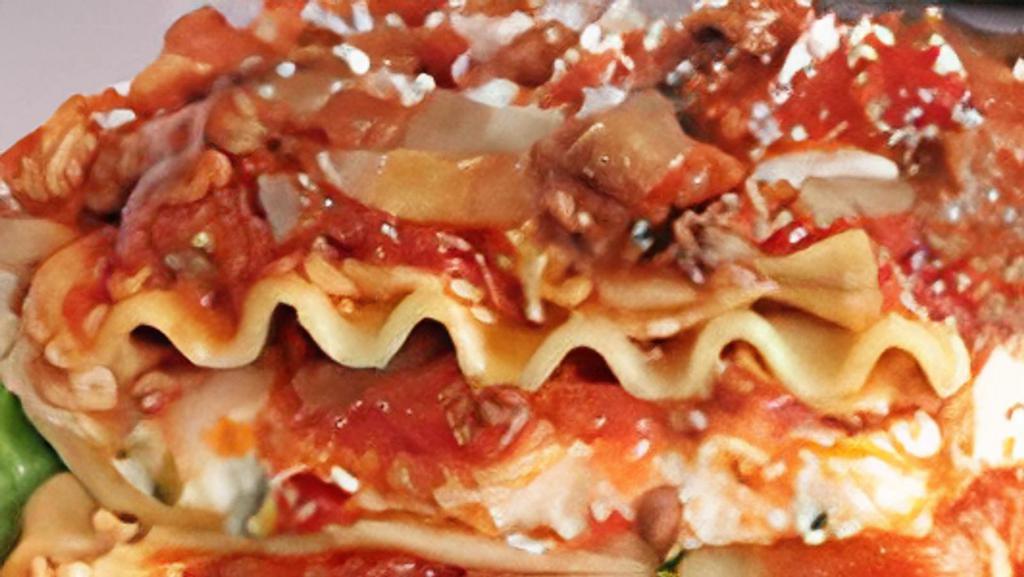 Meat Lasagna · Dinner salad, garlic bread, fork, mozzarella cheese.