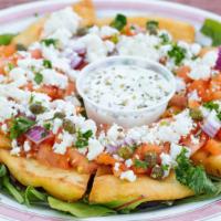 Greek Nachos · Fried pita wedges topped with onions, capers, tomatoes, feta cheese served with tzatziki.