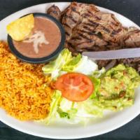 Carne Asada · Beef steak served with rice, beans, salad, guacamole and tortillas.