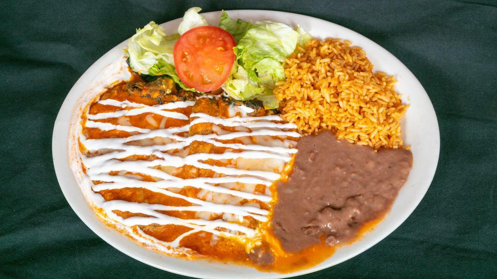 Chiles Rellenos · Two chili peppers stuffed with cheese or picadillo (ground beef with potatoes), with melted cheese and sour cream on top. Served with rice, beans and tortillas.