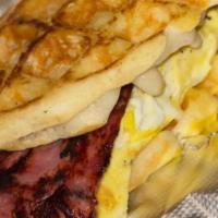 Bangin' Sandwich · Cinnamon roll waffle with cheese, eggs, and any choice of meat topped with icy glaze.