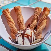 Churros · Warm churro sticks tossed in cinnamon and sugar. Served with vanilla ice cream and chocolate.