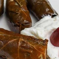 Dolmades · Stuffed grape leaves with rice and herbs. Served with a side of tzatziki.