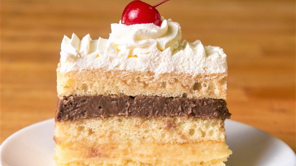 Rum Cake Slice · Sponge cake soaked in artificial rum with layers of fresh homemade whipped and vanilla and chocolate Italian custard.