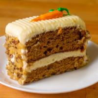 Carrot Cake Slice · Moist carrot cake layered and topped with fresh cream cheese frosting and walnuts.