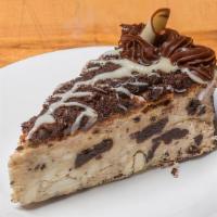 Oreo Cheesecake Slice · New York style cheesecake layered with Oreos and topped with chocolate fudge and Oreo pieces.