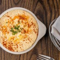 Hummus Bi Tahini · A combination of blended chick peas, tahini (sesame seed paste), lemon and garlic. Served wi...