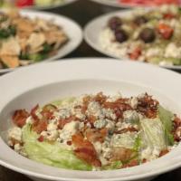 Wedge Salad · Hearts of iceberg lettuce topped with bacon and crumbled blue cheese along with our blue che...