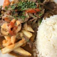 Lomo Saltado · Pieces of beef with tomatoes and onions sauteed accompanied with rice and french fries.