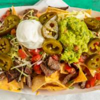 Super Taco Loaded Nachos · Meat, chili con queso, black beans, shredded lettuce, pico de gallo, jalapeños, guacamole, s...