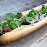 Grilled Pork Banh Mi · Grilled pork banh mi on a soft crunchy roll, with a spread of mayo and pate, cucumber, daiko...