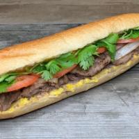 Spicy Steak Banh Mi · Steak banh mi on a soft crunchy roll, with a spread of mayo and pate, fried onion, tomato, a...