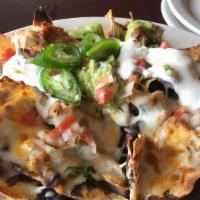 Nachos El Torogoz · Crispy corn chips covered with beans, sour cream, melted cheese, guacamole, jalapeno peppers...