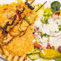 Chicken Kabab · Two skewers of grilled chicken kabab over rice with a side of tzatziki sauce and salad.