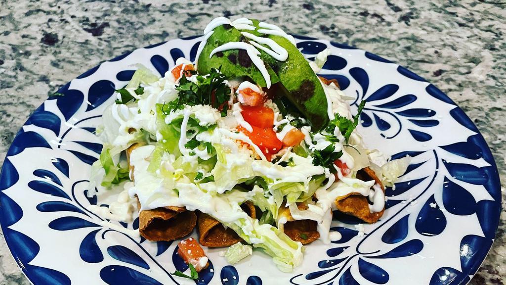 Crispy Taquitos  · (4)  Crispy chicken taquitos topped with lettuce, tomato, onion, tomato,  sour cream, fresh Mexican cheese, and avocado