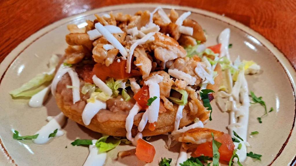 Grilled Chicken Sope · Fresh, flat corn tortilla, spread with beans, topped with lettuce, tomatoes,  cheese (mexican queso fresco)  and sour cream