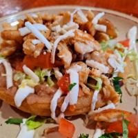 Tinga Sope · Fresh, flat corn tortilla, spread with beans, topped with  lettuce,  tomatoes,  cheese (mexi...