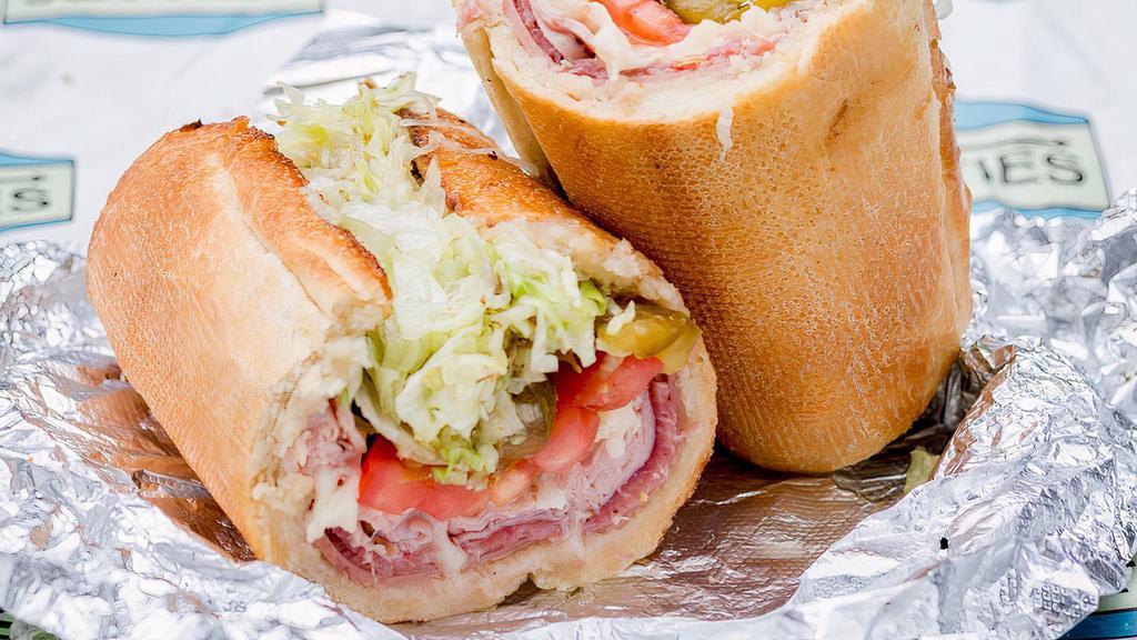 Quidnet · Mortadella, salami, shaved ham, provolone, lettuce, tomato, sweet peppers, thin red onion, and red wine vinaigrette on a toasted Italian sesame sub roll