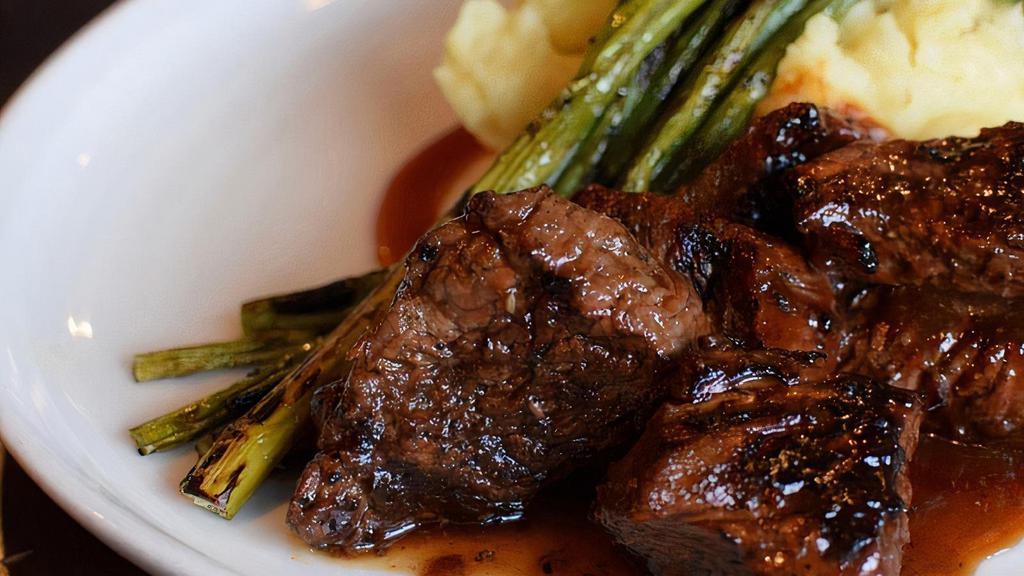 Bourbon Tips · Wood-grilled, marinated tenderloin tips garlic mashed potatoes, grilled asparagus, with a bourbon glaze