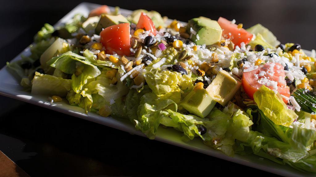 Chop Salad · Iceberg/romaine blend, roasted corn, black beans, tomato, red onion, pepitas, cucumbers, acocado and queso fresco with your chice of dressing.  (v, *v+)