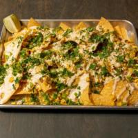 Nachos - Street Corn · Corn tortilla chips topped with queso fresco, roasted corn, street corn sauce and a green on...