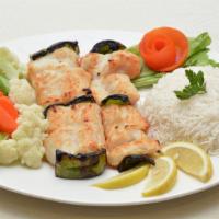 Salmon Kabob · Grilled fresh salmon fillet kabob is served with basmati rice, chickpeas, salad, pita bread ...