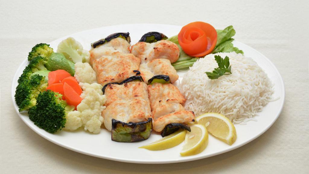 Salmon Kabob · Grilled fresh salmon fillet kabob is served with basmati rice, chickpeas, salad, pita bread & house sauce.