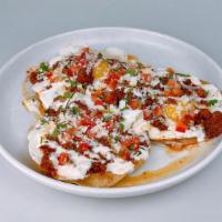 Huevos Ranchero · Corn tostadas, 3 sunny eggs*, chorizo, refried black beans, chile de arbol salsa, cotija che...