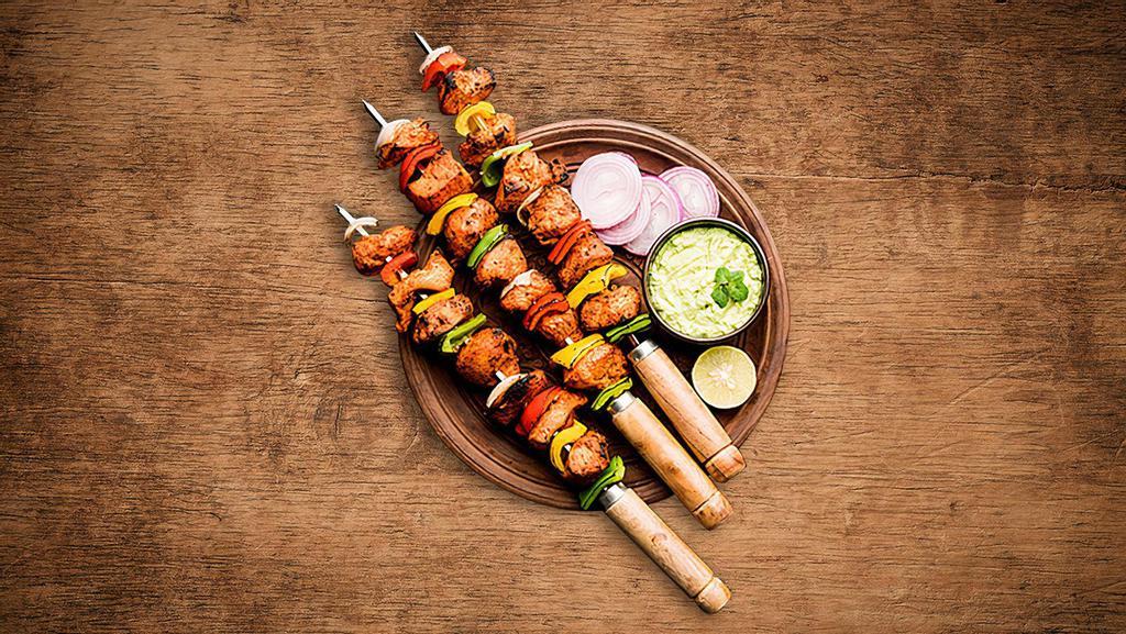 Charred Chicken Tikka  · Boneless chunks of chicken marinated in herbs and spices barbecued in a clay oven on a skewer.