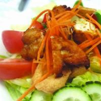 Salad Khag · Fried sliced chicken and fried tofu on a bed of green salad, served with peanut sauce and sw...