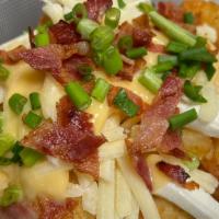 Baked Potato Tots · topped with shredded cheese, bacon, sour cream and green onion