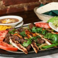 Grilled Chicken Fajitas · Grilled chicken fajitas are served over a bed of sauteed spanish onions, green peppers, cele...