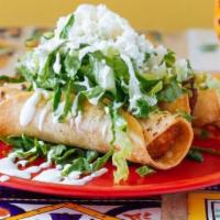 Tacos Dorados · Three crispy corn tortillas wrapped with potatoes and marinated chicken, topped with lettuce...