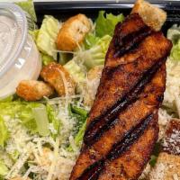 Salmon Caesar Salad · Classic Caesar salad topped with grilled salmon, croutons and shaved Parmesan cheese.