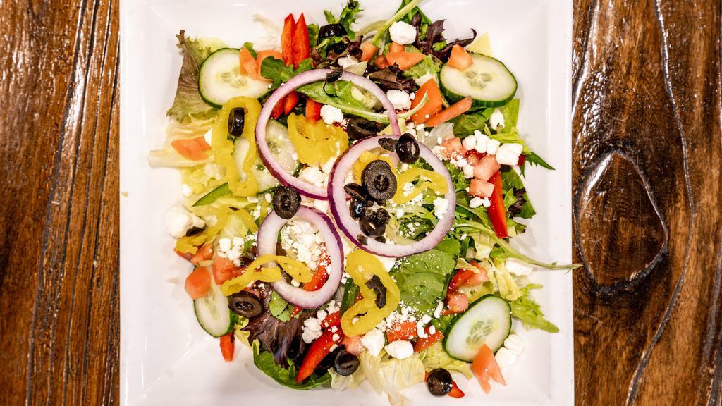 Greek Salad · Romaine & Iceberg lettuce topped with tomatoes, red onions, kalamata olives, banana peppers & crumbled feta cheese. Greek dressing.