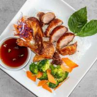 Crispy Duck · Roasted half-duck, tamarind sauce, steamed vegetables and rice.