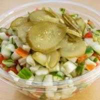 Israeli Salad · Israeli salad topped with Israeli pickles and tahini dressing.
