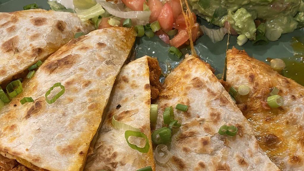 Ana Maria Quesadilla · Our house quesadilla with Monterrey and Cheddar cheese, add shredded chicken, ground Beef or Mexican chorizo. Served with lettuce, guacamole, sour cream, tomatoes, and green onions.
