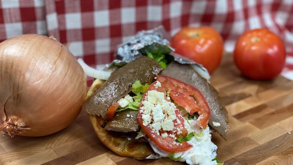 Yeros Sandwich · Strips of grilled lamb and beef with tomatoes, onion, feta, tzatziki sauce and fries wrapped in a lightly toasted pita bread.