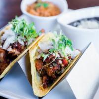 Chicken Tinga Tacos · Shredded chicken cooked in spicy sour annatto broth, onion, Cotija cheese