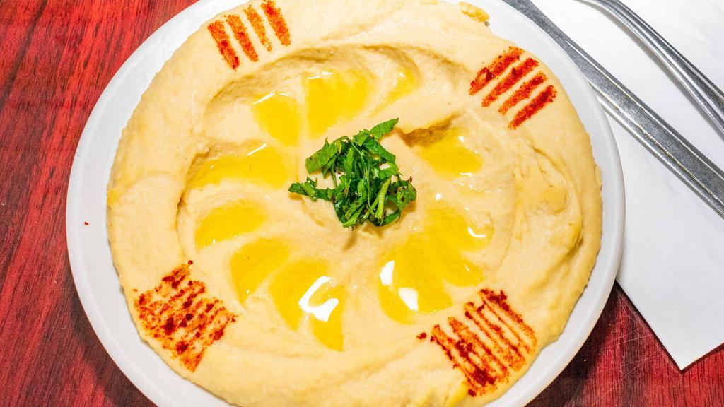 Hummus · Pureed chickpeas blended with tahini sauce, lemon juice, and garlic. Served with pita bread.