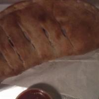 Italian Stromboli · Made with pepperoni, salami, ham baked with mozzarella cheese and sauce, fried onions and gr...